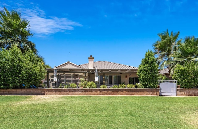 rear view of property with a lawn