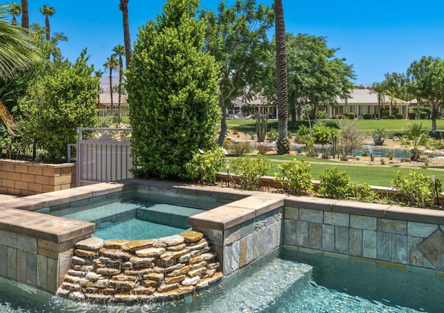 view of swimming pool featuring an in ground hot tub and a yard