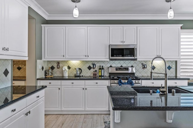 kitchen with stainless steel appliances, pendant lighting, white cabinetry, and sink