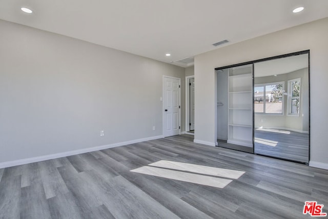 unfurnished bedroom featuring light wood-type flooring and a closet