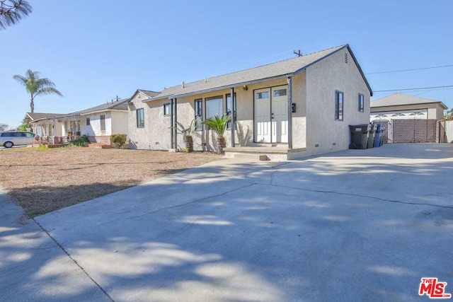 view of front of house with a garage and an outbuilding