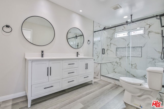 bathroom with an enclosed shower, vanity, wood-type flooring, and toilet