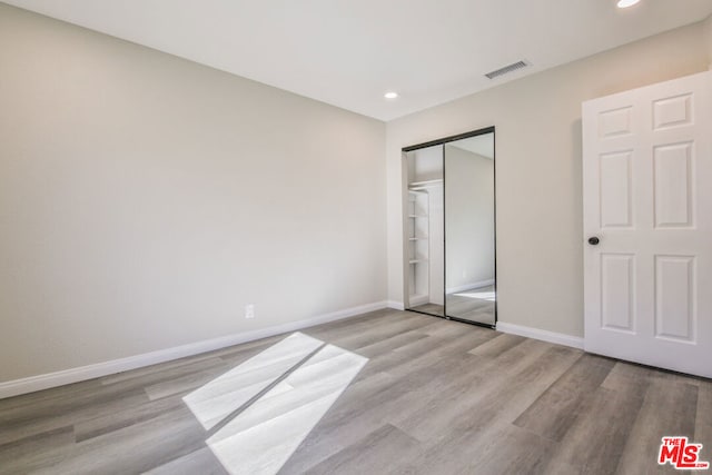 unfurnished bedroom featuring a closet and light hardwood / wood-style flooring