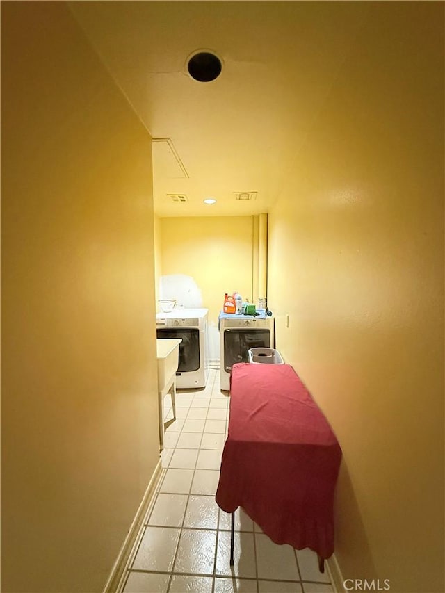 hall featuring separate washer and dryer and light tile patterned flooring