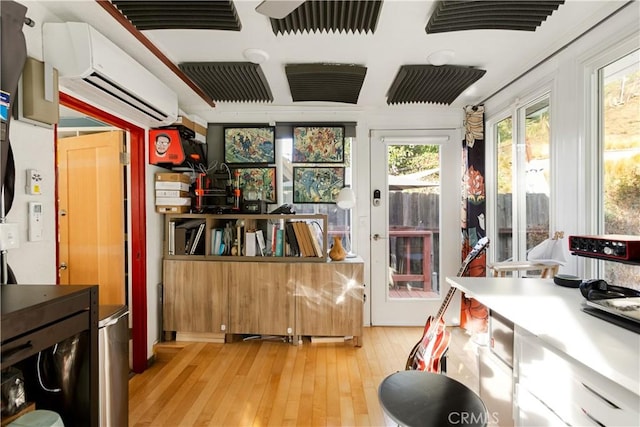 misc room with light hardwood / wood-style flooring and a wall unit AC