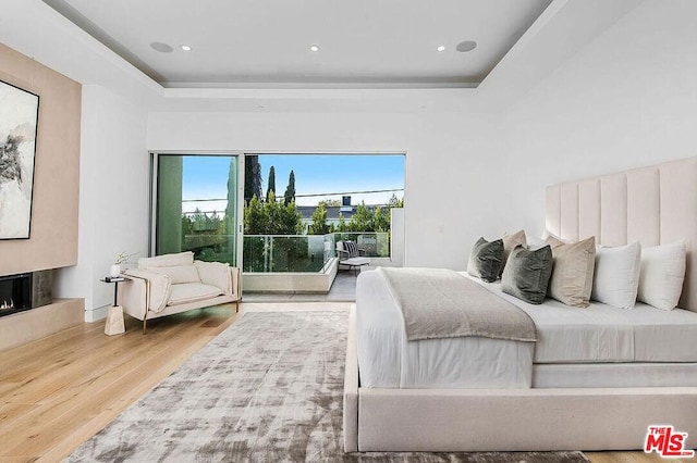 bedroom with a tray ceiling and hardwood / wood-style floors