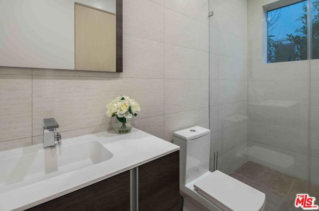 bathroom featuring tile walls, toilet, and vanity