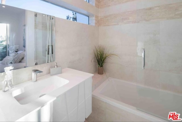 bathroom featuring a relaxing tiled tub and sink