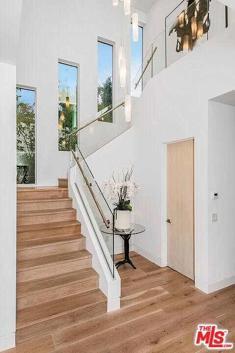 stairway featuring hardwood / wood-style floors and a towering ceiling