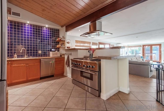 kitchen with sink, decorative backsplash, exhaust hood, light tile patterned floors, and stainless steel appliances