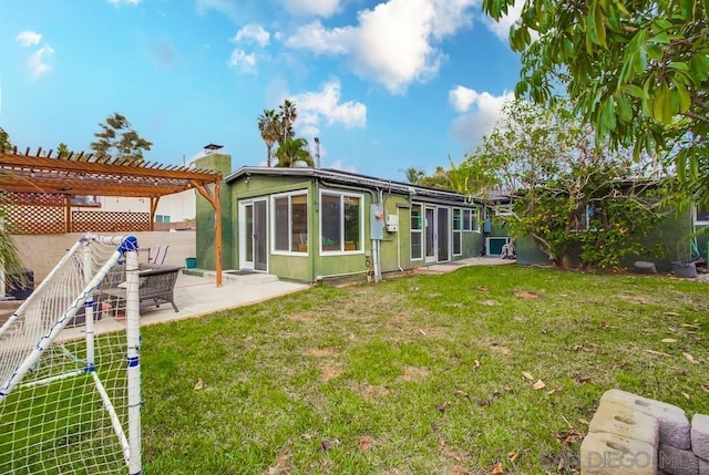 back of property with a patio, a lawn, and a pergola