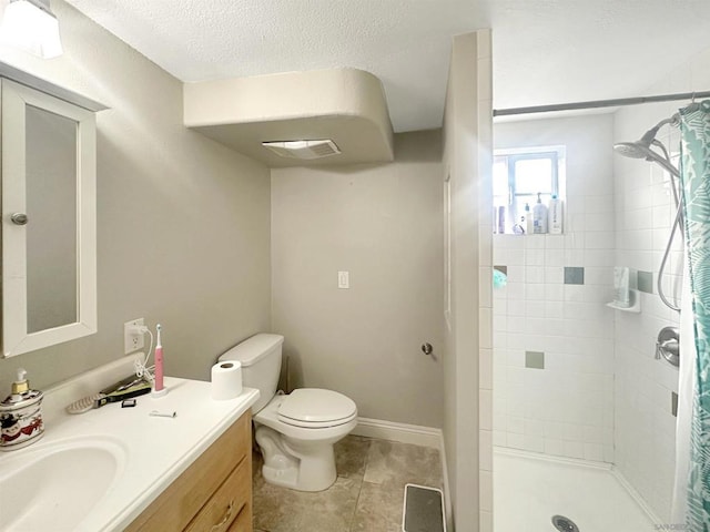 bathroom featuring curtained shower, tile patterned flooring, vanity, toilet, and a textured ceiling