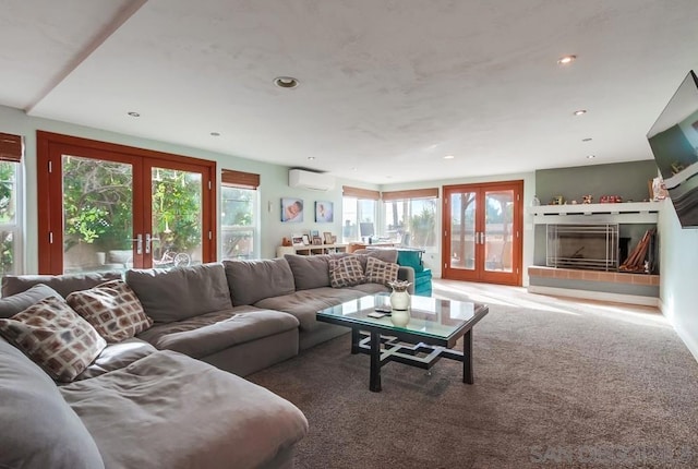 carpeted living room with french doors, a tiled fireplace, and a wall unit AC