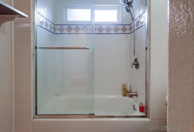 bathroom featuring combined bath / shower with glass door