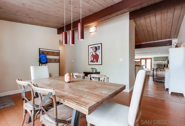 dining space with lofted ceiling with beams, hardwood / wood-style floors, and wooden ceiling