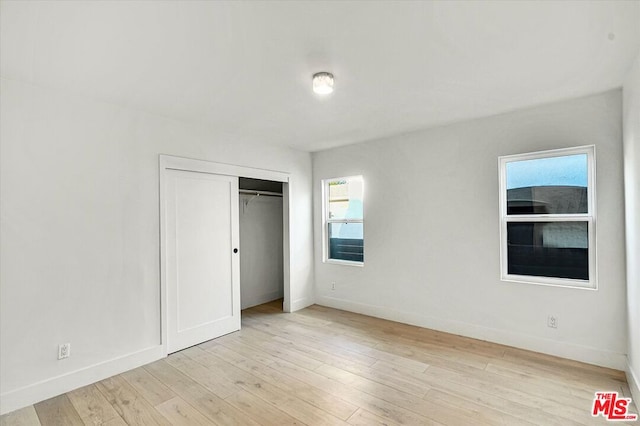 unfurnished bedroom featuring a closet and light hardwood / wood-style flooring