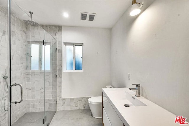 bathroom with a shower with door, toilet, and vanity