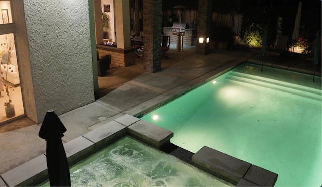 view of swimming pool featuring a patio area and an in ground hot tub