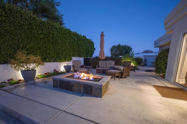 view of patio with an outdoor living space with a fire pit