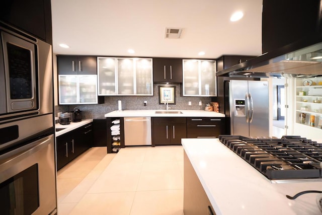 kitchen with backsplash, sink, light tile patterned flooring, appliances with stainless steel finishes, and island range hood