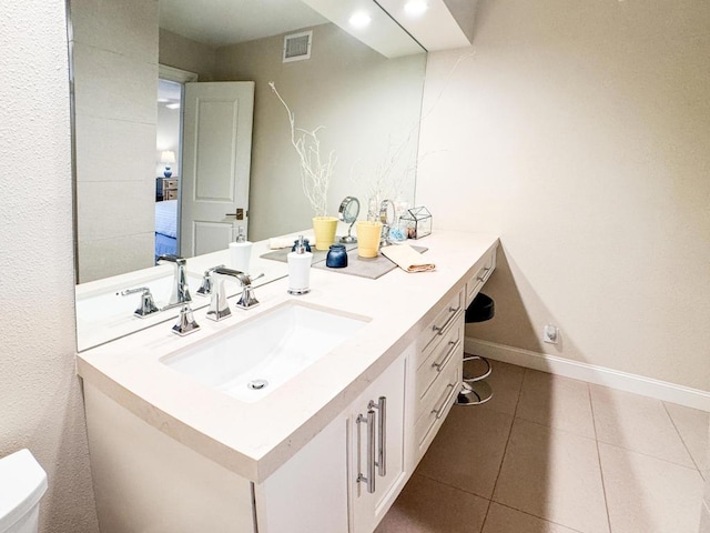 bathroom with toilet, tile patterned floors, and vanity