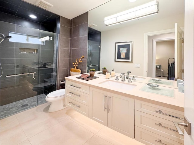 bathroom with toilet, vanity, a shower with door, and tile patterned floors