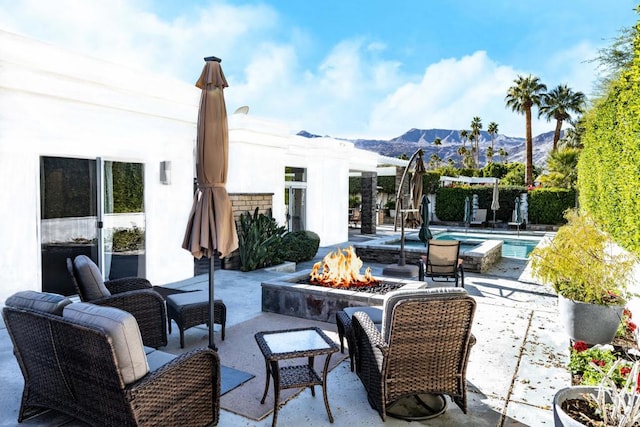 view of patio with a mountain view and a fire pit