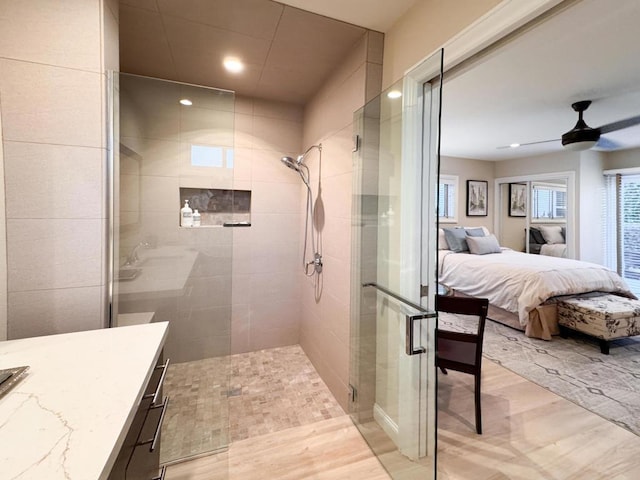 bathroom featuring ceiling fan, vanity, and a shower with shower door