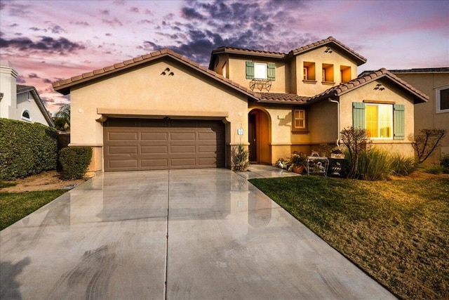 mediterranean / spanish-style house featuring a garage and a lawn