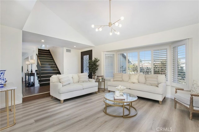 living room with high vaulted ceiling, hardwood / wood-style flooring, and a notable chandelier