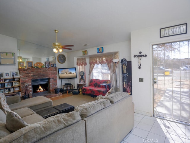 living room with light tile patterned floors, a fireplace, and ceiling fan