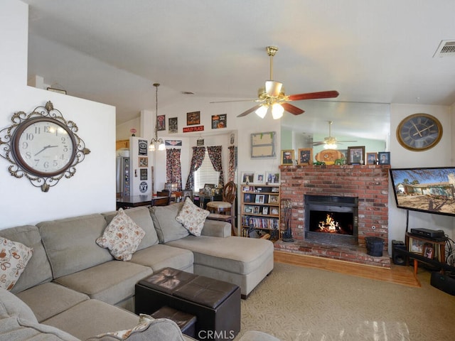 living room featuring lofted ceiling, a brick fireplace, and light hardwood / wood-style floors