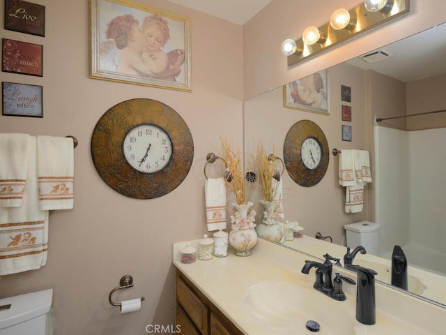 bathroom featuring a shower, vanity, and toilet