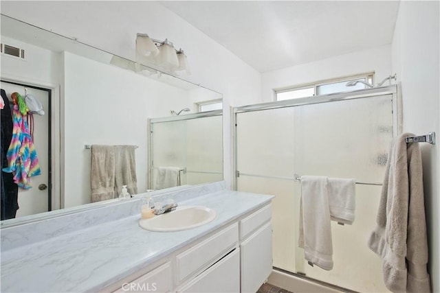 bathroom with vanity and a shower with door