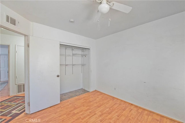 unfurnished bedroom featuring ceiling fan, a closet, and light hardwood / wood-style flooring