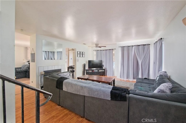 living room with ceiling fan, hardwood / wood-style flooring, and a fireplace