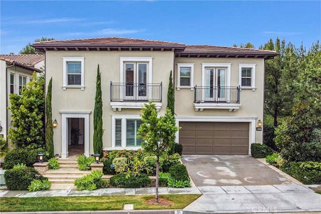 mediterranean / spanish-style home with french doors, a balcony, and a garage