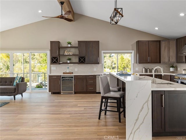 kitchen featuring sink, wine cooler, dark brown cabinetry, and decorative backsplash