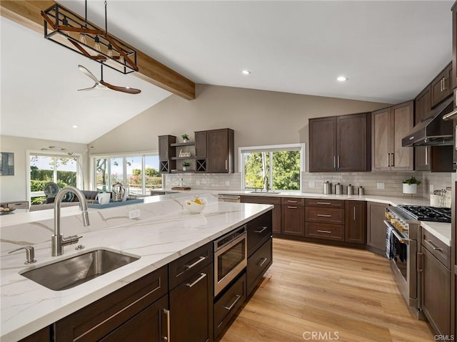 kitchen with dark brown cabinetry, sink, vaulted ceiling with beams, light hardwood / wood-style flooring, and stainless steel appliances