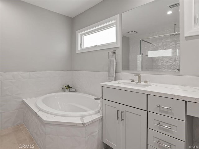 bathroom with tile patterned floors, shower with separate bathtub, and vanity