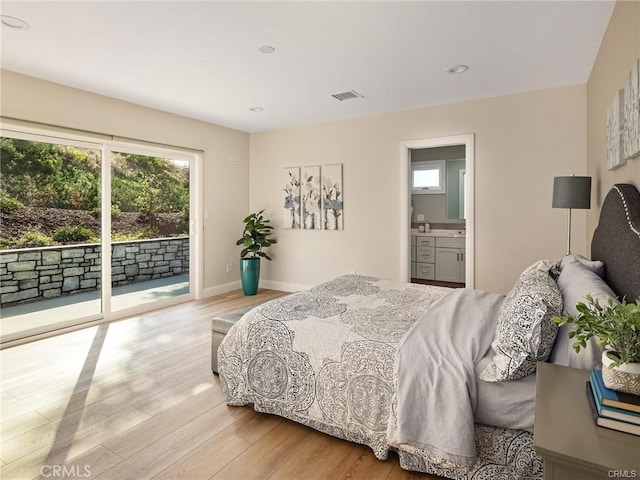 bedroom with connected bathroom, access to exterior, and light wood-type flooring