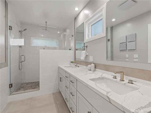 bathroom with walk in shower, tile patterned floors, vanity, and tile walls