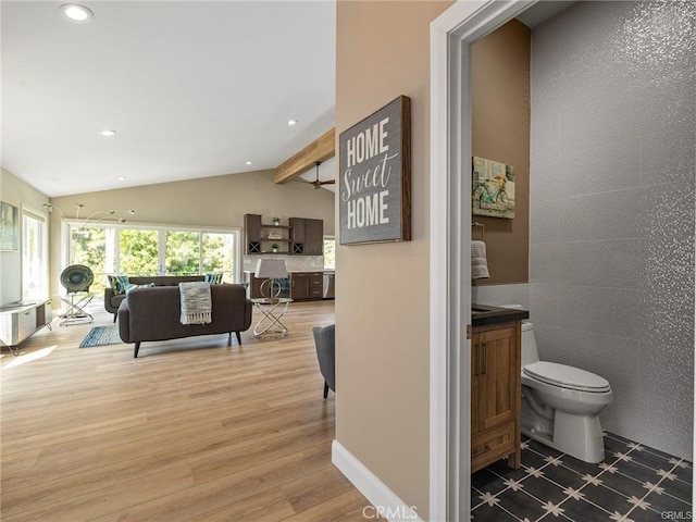 interior space featuring hardwood / wood-style flooring, vaulted ceiling with beams, and toilet