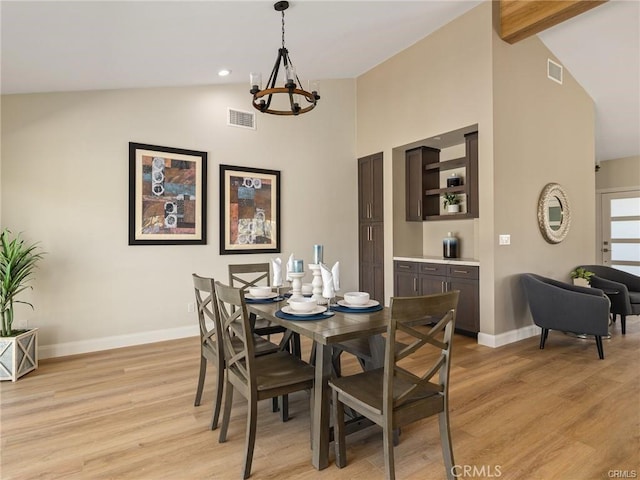 dining area featuring a notable chandelier, lofted ceiling with beams, and light wood-type flooring