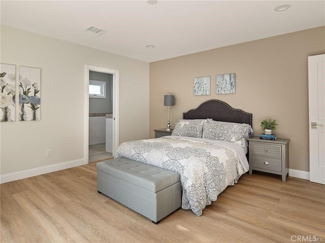 bedroom featuring ensuite bathroom and light hardwood / wood-style flooring