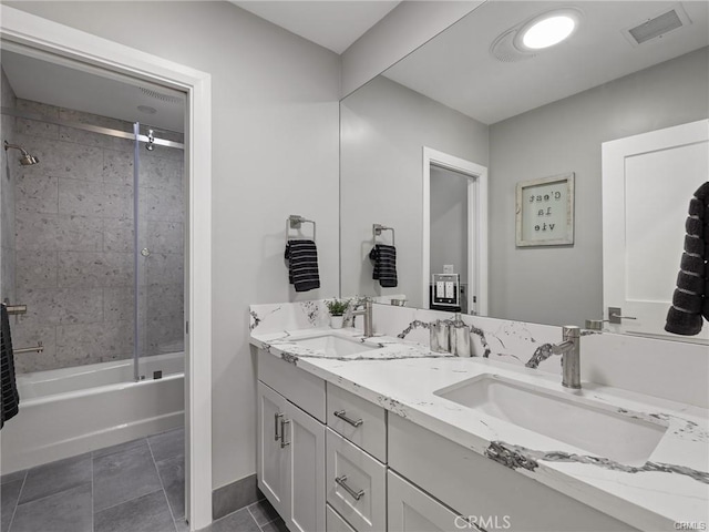 bathroom with vanity, tiled shower / bath combo, and tile patterned flooring