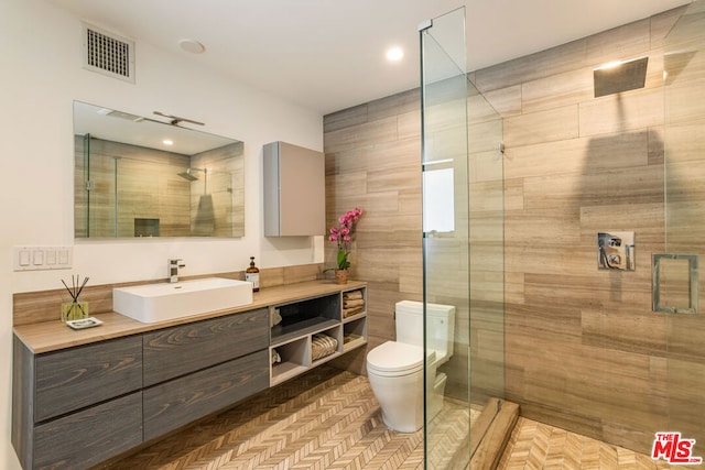 bathroom featuring toilet, vanity, and an enclosed shower