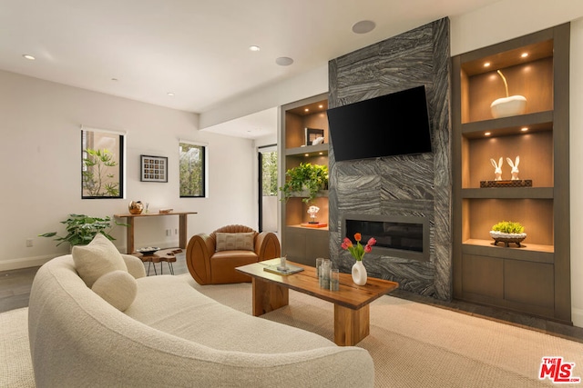 living room featuring a premium fireplace and built in shelves