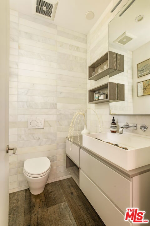 bathroom with toilet, vanity, and hardwood / wood-style flooring