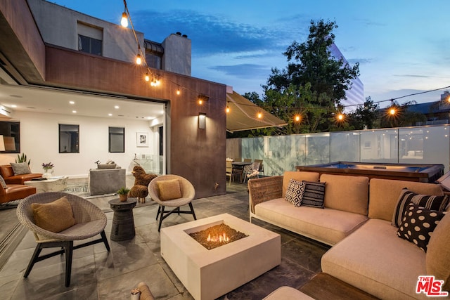 patio terrace at dusk with an outdoor living space with a fire pit